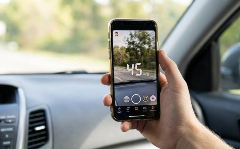 Snapchat speedometer filter showing speed on a smartphone screen while driving